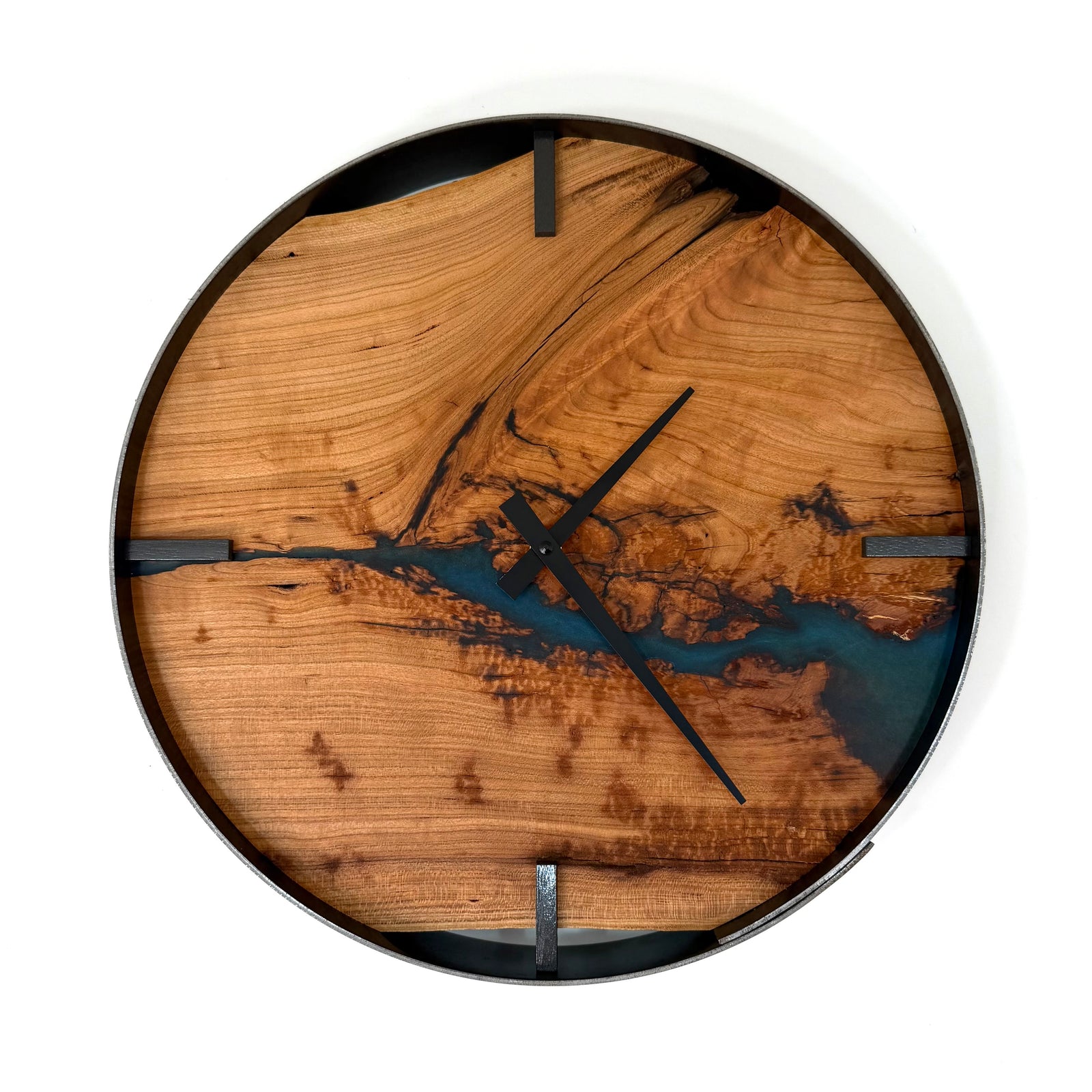 A round wall clock with a natural cherry wood grain face featuring a metallic teal resin river design, black hands, and a black outer rim, shown against a plain white background.